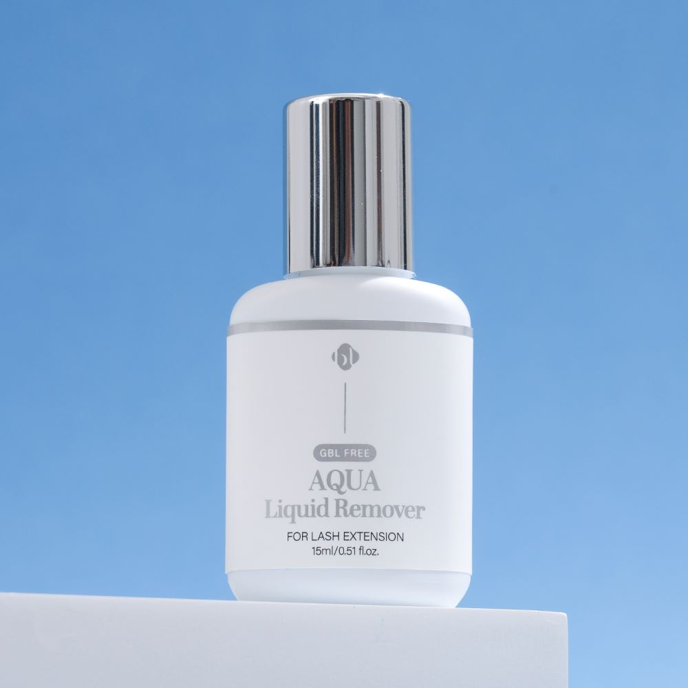 BL Lashes Aqua Liquid Remover 15ml bottle with a silver cap displayed on a white block against a clear blue background.