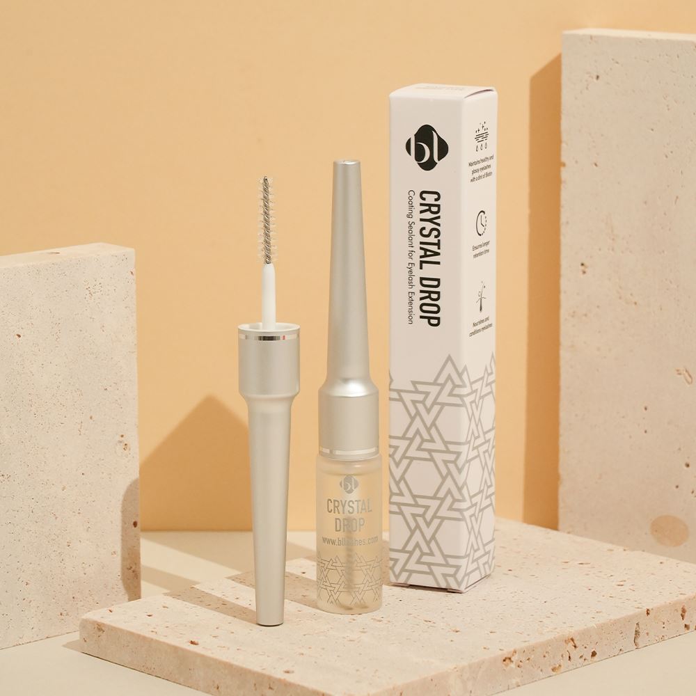 BL Lashes Crystal Drop Coating Sealant bottle, opened mascara wand applicator, and its packaging box displayed on textured stone blocks.