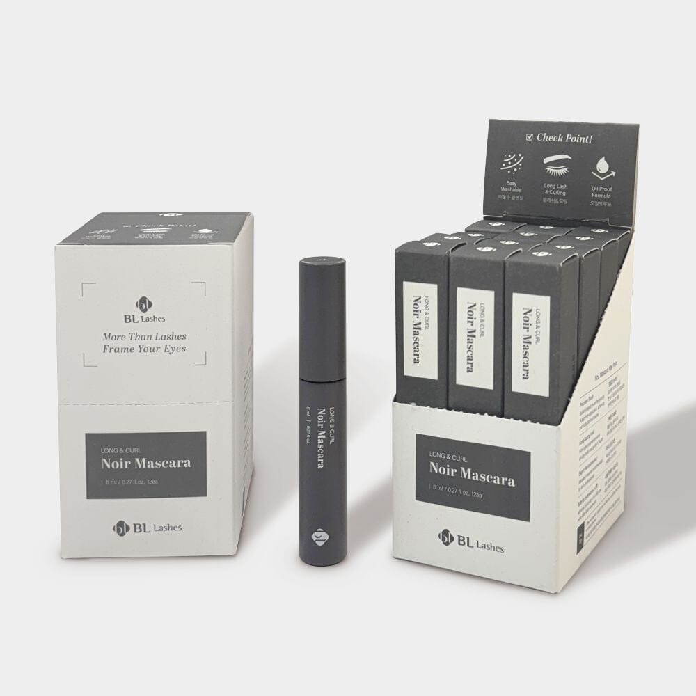 A tube of BL Lashes Noir Mascara displayed alongside its closed packaging box and an open retail display stand holding multiple individual boxes.